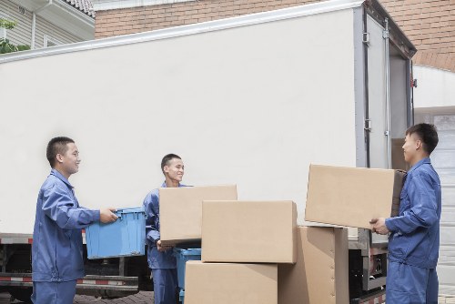 Professional movers loading household items into a removals van